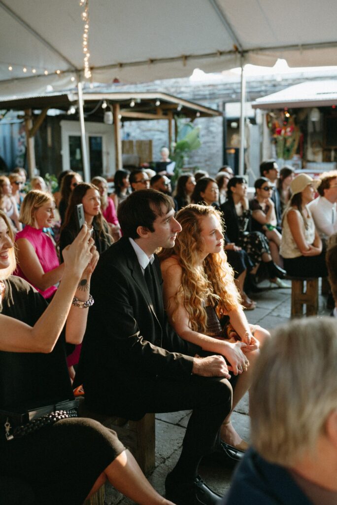 Guests during a ceremony at a wedding day at Roberta's Pizza in Williamsburg, Brooklyn NYC. 