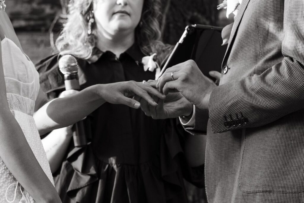 A bride and groom exchanging rings during a wedding day at Roberta's Pizza in Williamsburg, Brooklyn NYC. 